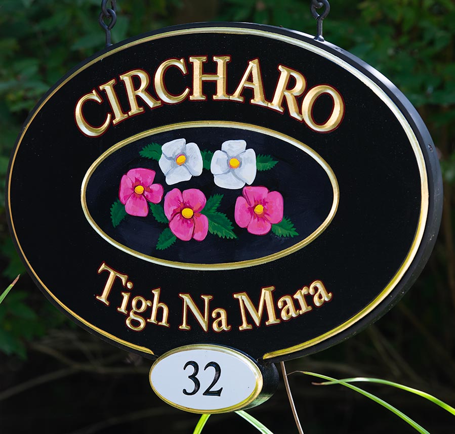 carved home sign with hand painted primroses